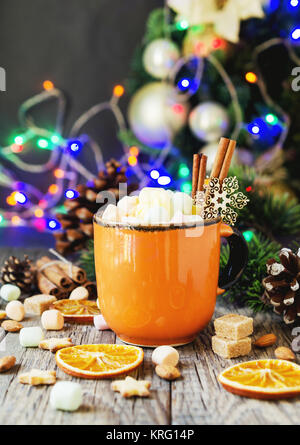 Una tazza di Natale cioccolata calda con marshmallow sullo sfondo del nuovo anno di luci e decorazioni, il fuoco selettivo Foto Stock