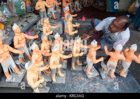 Un pittore di aggiungere colore a Durga idoli nel quartiere di ceramiche di Kumartuli in Kolkata, India Foto Stock