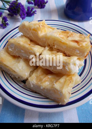 Strudel di formaggio sulla piastra blu e asciugamano, verticale Foto Stock