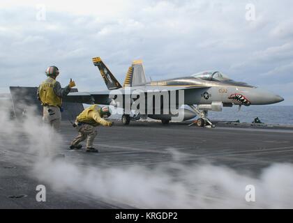 I marinai usa il segnale per il lancio di un Boeing F/A-18E Super Hornet fighter aircraft dal ponte di volo a bordo della USN Nimitz-class portaerei USS George Washington, 18 novembre 2009 nell'Oceano Pacifico. Foto Stock