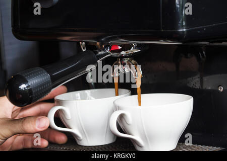 Macchina per caffè facendo due tazza di espresso fresco sfondo. Espresso è un caffè servito forzando una piccola quantità di circa di acqua bollente. Foto Stock