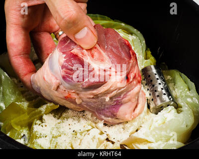 Lo chef prepara un tradizionale piatto di norvegesi, agnello e il cavolo con grani di pepe Foto Stock