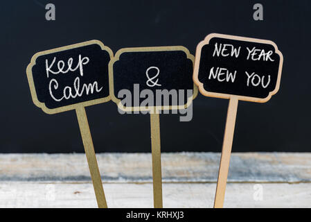 Mantenere la calma e di Nuovo Anno Nuovo messaggio è scritto con un gessetto sulla mini etichette di Blackboard Foto Stock