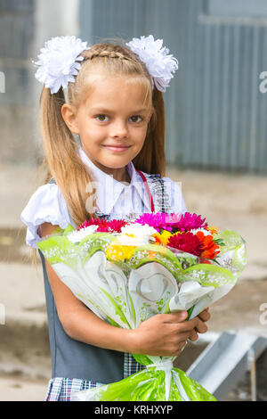 Su ritratto di un periodo di sette anni di scuola ragazza con un mazzo di fiori Foto Stock