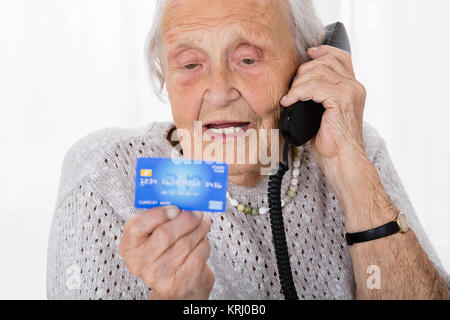 Senior donna con carta di credito sul telefono Foto Stock