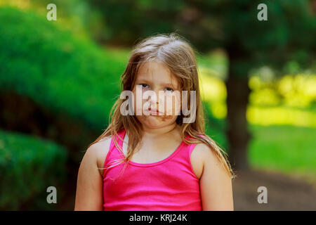 Bellissima bambina sulla strada attraverso pozzanghere in stivali di gomma Foto Stock