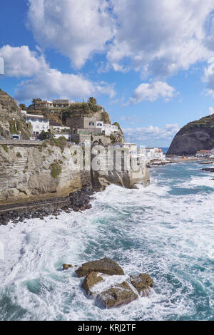 Famoso Sant'Angelo Village sulle scogliere sul mare, selvaggio con onde che si infrangono contro gli scogli - Ischia, Italia Foto Stock