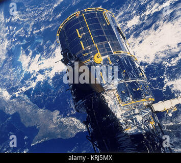 La distribuzione del telescopio spaziale Hubble, 1990. Il Telescopio Spaziale Hubble (HST) è stato messo in orbita dalla navetta spaziale Discovery, missione STS-31 il 24 aprile 1990. HST, ancora nella morsa del shuttle per il braccio del robot, è backdropped contro Cuba e le Bahamas. HST è stato progettato per vedere sette volte di più in uno spazio a quello che era stato possibile prima, senza la distorsione causata dall'atmosfera terrestre. Problemi con il suo gigantesco specchio significava che inizialmente non funziona così bene come previsto. Ottiche correttive sono state installate nel 1993, migliorando notevolmente il telescopio le prestazioni, consentendo ad esso di v Foto Stock