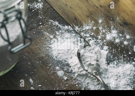 Arrow-polvere versato su un vecchio tavolo di legno. Mostrato con antichi cucchiaio d'argento e vaso di grandi dimensioni. Foto Stock