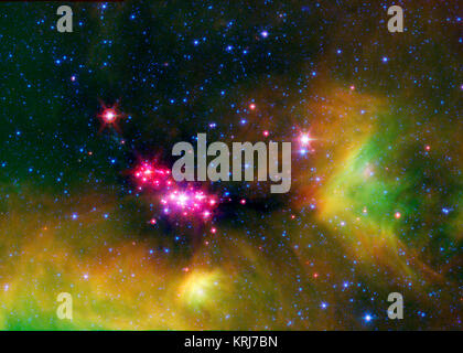 Infant Star sono incandescente gloriosamente in questa immagine infrarossa del Serpens star-regione di formatura, catturato dalla NASA il telescopio spaziale Spitzer. Il colore rosso-rosa punti sono baby stelle profondamente radicati in cosmic nube di gas e polvere che è collassata per crearlo. Un disco polveroso di detriti cosmici, o 'protoplanetary disk", che può eventualmente formare pianeti, circonda il neonato stelle. I ciuffi di verde in tutta l'immagine indicano la presenza di ricche di carbonio molecole chiamate, gli idrocarburi policiclici aromatici (IPA). Sulla Terra, gli IPA può essere trovato su carbonizzati area barbecue e nei gas di scarico delle automobili. Blue spe Foto Stock