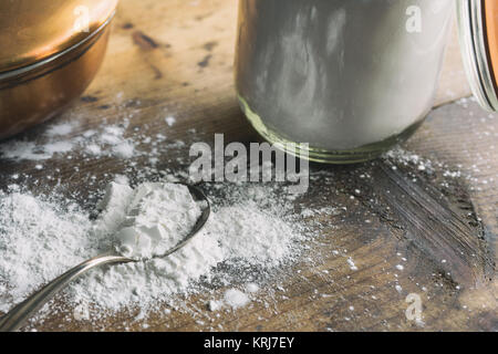 Arrow-polvere versato su un vecchio tavolo di legno. Mostrato con antichi cucchiaio d'argento e vaso di grandi dimensioni. Foto Stock