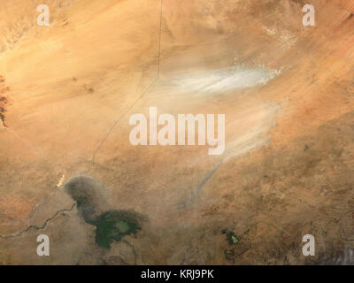La polvere dalla depressione Bodele in Ciad, in Africa (immagine a destra), soffia attraverso il lago Ciad regione in questa modis.gsfc.nasa.gov risoluzione moderata Imaging Spectroradiometer (dello spettroradiometro MODIS) immagine presa dal terra.nasa.gov/ satellite Terra il 10 novembre 2003. Come recentemente come il sessanta, il lago Ciad riempito una zona in depressione approssimativamente le dimensioni del lago Erie in Nord America, ma la mancanza di pioggia e aumento della domanda di acqua di irrigazione hanno ridotto sulle coste del lago, lasciando molto del Bodele depressione a secco. Ora tempeste di polvere nella depressione Bodele sono comuni. L'area pianeggiante è un ma Foto Stock