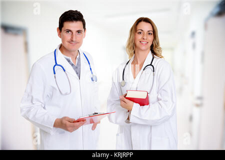 Giovane, Gentile team di medici con libro in camice Foto Stock