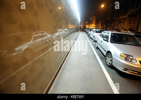 Zagabria, Croazia - 8 Settembre 2017 : schierate vetture parcheggiate accanto al marciapiede riflettendo in parete edilizia di notte nel centro della città di Zagreb, CRO Foto Stock