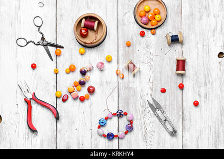 Perle rotonde per bracciali e collane bianco su sfondo in legno.Vista dall'alto Foto Stock