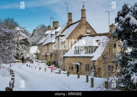 Chiesa row cottages di Chedworth villaggio nel dicembre neve. Chedworth, Cotswolds, Gloucestershire, Inghilterra Foto Stock
