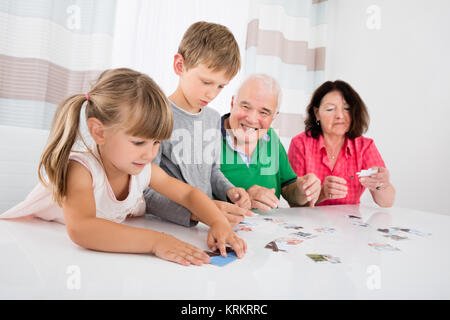 Multi generazione Famiglia risolvendo puzzle insieme Foto Stock