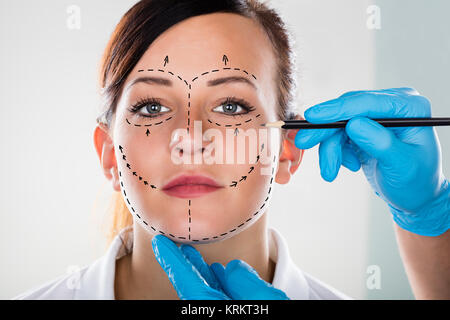 Persona del disegno a mano linea di correzione sul volto di donna Foto Stock