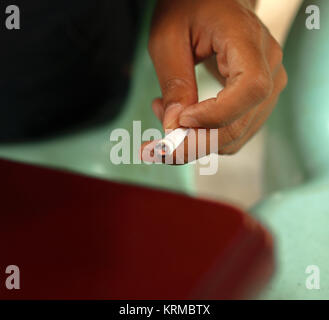 CLOSE-up shot di mano azienda sigaretta accesa Foto Stock