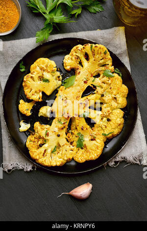 Cavolfiore fritto bistecca con erbe e spezie sulla piastra. Vista superiore, flay lay Foto Stock