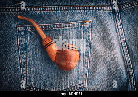 Tubo di legno per il tabacco è nella tasca posteriore dei vecchi jeans blu Foto Stock