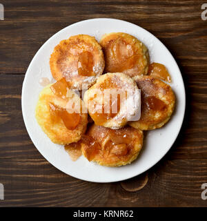 Ricotta pancake caramellato con fette di mela sul tavolo di legno. Vista superiore, piatto laici. Foto Stock