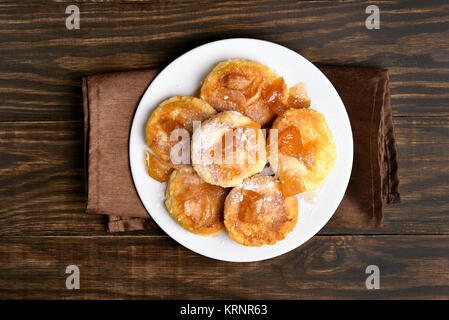 Le frittelle, ricotta pancake caramellato con fette di mela sul tavolo di legno. Vista superiore, piatto laici. Foto Stock