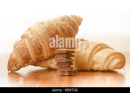 Due cornetti al forno con barrette di cioccolato. Foto Stock