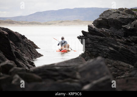 Famiglia in viaggio che si diverte sulla spiaggia a giocare a calcio, correre, saltare e divertirsi in Donegal, Repubblica di Irlanda Foto Stock