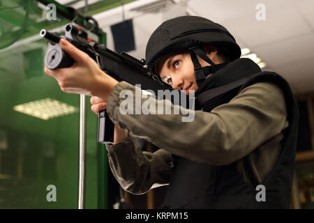 Policjantka na strzelnicy strzela z karabinu Foto Stock