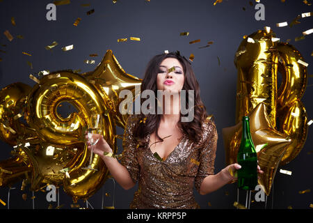 Donna sorridente con alcol per celebrare il capodanno Foto Stock