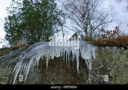 Alcuni icicless pendere dalla scogliera Foto Stock