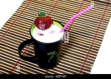 Cocktail di latte in una tazza nera, è decorato con fragola Foto Stock