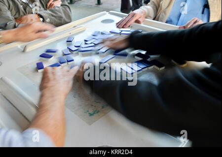 Gruppo di anziani senior uomini cubano GIOCA Domino in Domino Park/Maximo Gomez Park sulla Calle Ocho, Little Havana di Miami, Florida, Stati Uniti d'America. Foto Stock