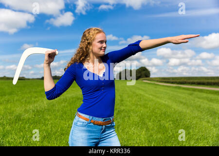 Giovane donna caucasica gettando boomerang in natura Foto Stock