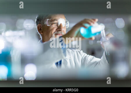 Maschio senior researcher di effettuare attività di ricerca scientifica in un laboratorio Foto Stock