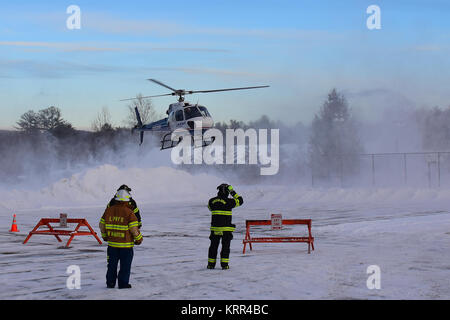 Evacuazione di emergenza elicottero in arrivo per un atterraggio su una coperta di neve elisuperficie con due vigili del fuoco in attesa per assistere. in speculatore, NY, STATI UNITI D'AMERICA Foto Stock