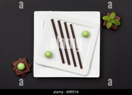 Un assortimento di cioccolatini alla menta e due piastre bianche Foto Stock