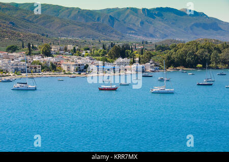 Barche ancorate nelle acque del golfo Saronico mare di fronte la capitale dell'isola di pori e il fondo con le montagne dell'isola Foto Stock