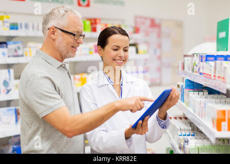 Il farmacista e il cliente con i tablet pc in farmacia Foto Stock