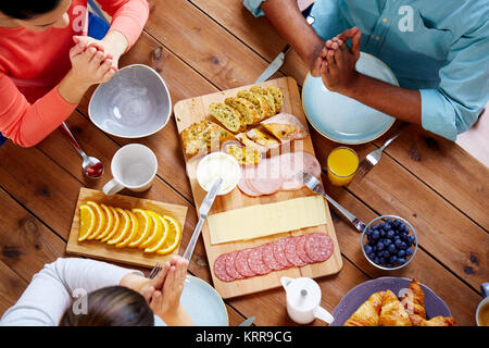 Gruppo di persone a tavola pregare prima del pasto Foto Stock