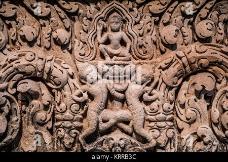 Khmer Sandstone Lintel con Wrestling Warriors Arthur M. Sackler Gallery Washington DC / WASHINGTON DC — un architrave in pietra arenaria Khmer dell'XI secolo raffigurante due figure di wrestling intrecciate intorno a uno stelo di loto è esposto alla Arthur M. Sackler Gallery. I guerrieri scolpiti, con un piede premuto contro la coscia dell'altro, probabilmente rappresentano Bhima e Duryodhana dell'epico indiano Mahabharata, mentre una misteriosa divinità siede in cima al loto in una posizione inginocchiata simile alle raffigurazioni degli auriga Khmer. L'elemento architettonico, che misura 56,2 x 161,3 x 21,9 cm (22 1/8 x 63 1/2 x 8 5/8 pollici), Foto Stock