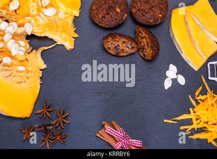 Muffin di zucca e i pezzi di zucca freschi su uno sfondo nero, spazio vuoto Foto Stock