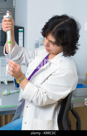 Senior Scientist funziona con pipetta automatica nel laboratorio biologico Foto Stock