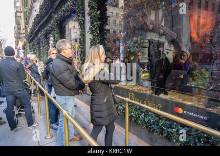 Una folla di acquirenti e turisti sfoglia il Saks Fifth Avenue windows sulla Fifth Avenue nel centro di Manhattan a New York domenica 10 dicembre, 2017. Solo 14 più giornate di shopping fino a Natale. (© Richard B. Levine) Foto Stock