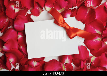 Scheda Mockup su rosso petali di rosa per il giorno di San Valentino. Appartamento laico, vista dall'alto con un posto per il vostro testo. Foto Stock