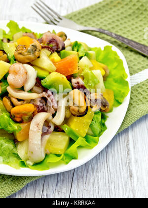 L'insalata di frutti di mare e di avocado nella piastra sulla scheda di luce Foto Stock