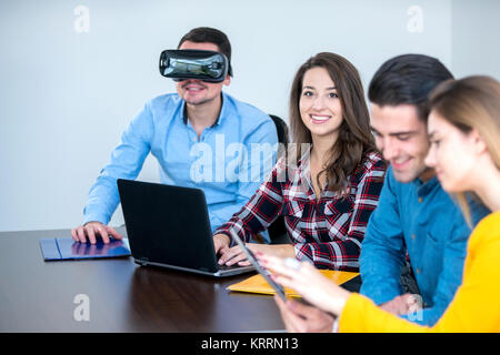 Team di persone motivate, utilizzando vari dispositivi ad una fusione di avvio. concetto, il lavoro di squadra Foto Stock