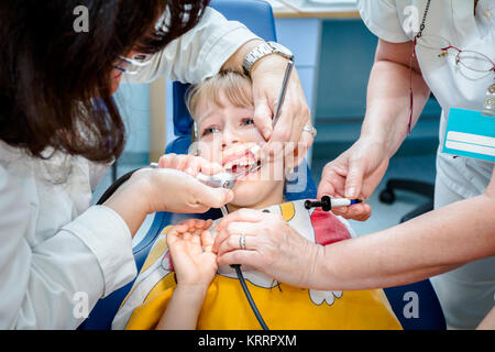 Preschooler bambino è in studio dentistico, preparazione per la rimozione dei denti di latte. Foto Stock