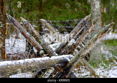 Barricata protettiva di pali in legno e le bobine di filo spinato di acciaio. Foto Stock